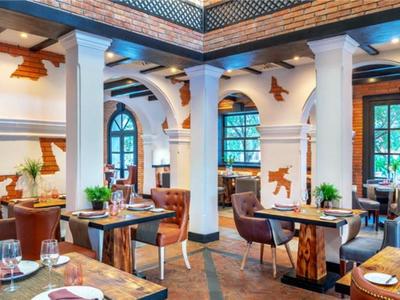 Licht restaurant met ronde zuilen, houten plafonds en elegant gedekte tafels