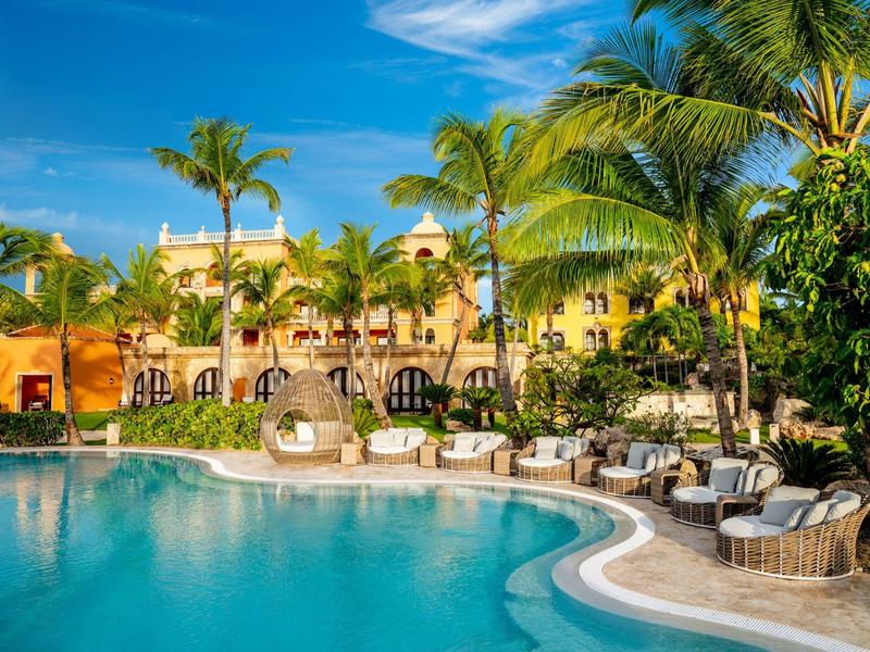 Luxe zwembadgebied met palmbomen en comfortabele zitplaatsen voor een hotel.