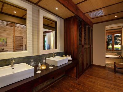 Modernes Badezimmer mit zwei Waschbecken, großem Spiegel und Holzboden.