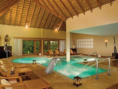 Gemütlicher Spa-Bereich mit beheiztem Whirlpool und Massagestuhl unter Holzdach