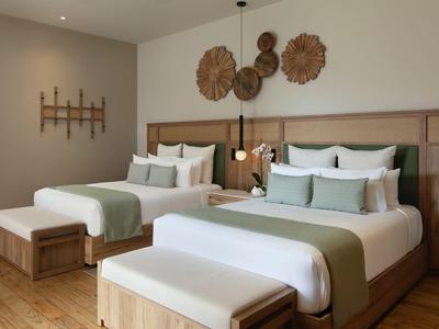 Habitación de hotel moderna con dos camas, muebles de madera y arte decorativo en la pared.