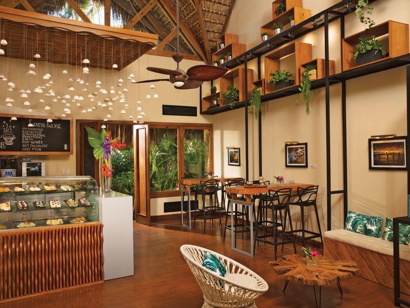 Gemütlicher Hotel-Loungebereich mit Holzdecke, Sitzgelegenheiten und dekorativen Pflanzen.