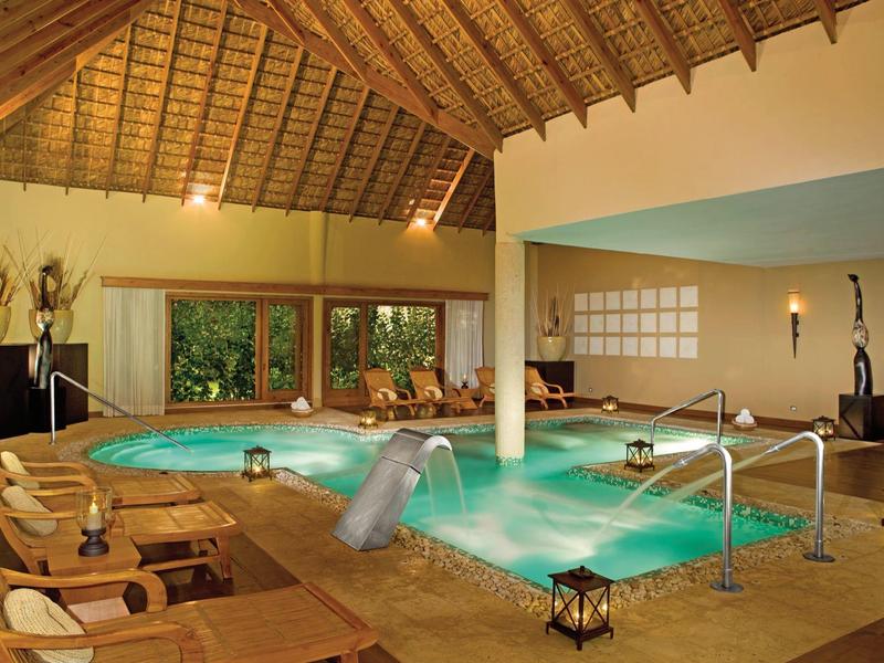 Gemütlicher Spa-Bereich mit beheiztem Whirlpool und Massagestuhl unter Holzdach