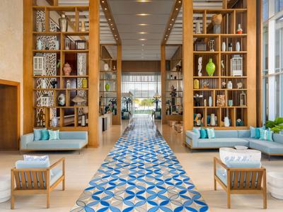 Moderní hotelová lobby s modrou vzorovanou dlaždicovou cestou a dřevěnými policemi