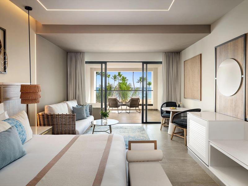 Modern eingerichtetes Schlafzimmer mit großem Bett, Balkon und hellem, neutralem Farbton.