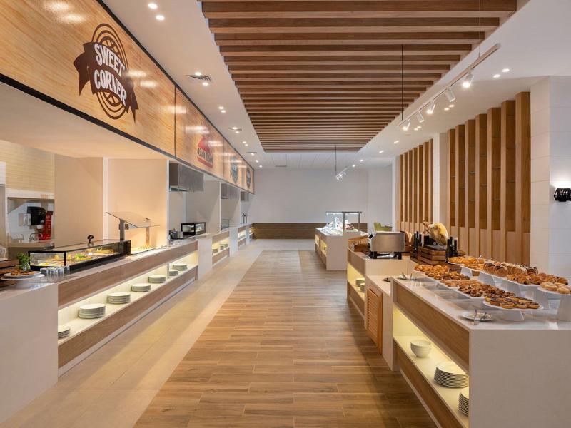 Moderner Bäckerladen mit Holzfußboden, beleuchteten Theken und Holzdeckenverkleidung.