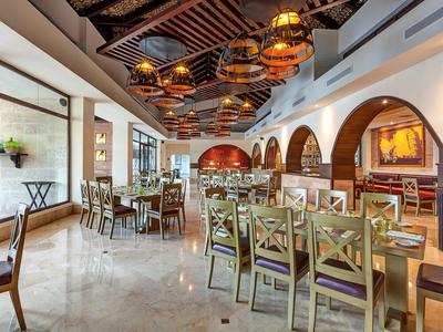 Modernes Restaurant mit Holzmöbeln und warmem Lichtkonzept in einem Hotel.