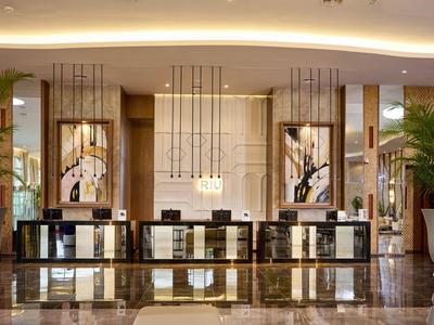 Elegant hotel reception with large front desk and stylish lighting.