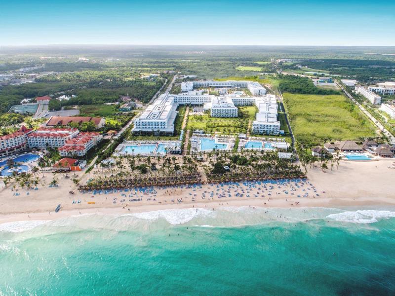 Large beach resort with multiple buildings, pool areas, and direct access to the sea.