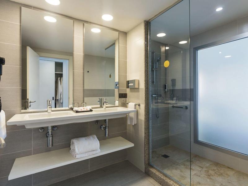 Modern bathroom with two sinks and a shower cabin with glass partition.