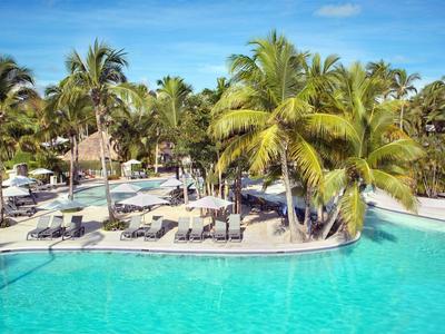 Velký bazén s palmami a lehátky v tropickém hotelu