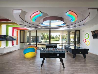 Modern recreation room with foosball, air hockey, bean bags, and colorful LED lights.