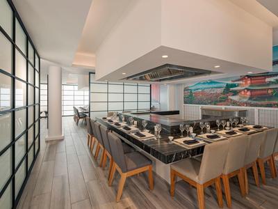 Modern dining area with large table and chairs in a stylish, bright room.