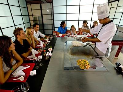 Group dining at Japanese teppanyaki table with chef in traditional attire