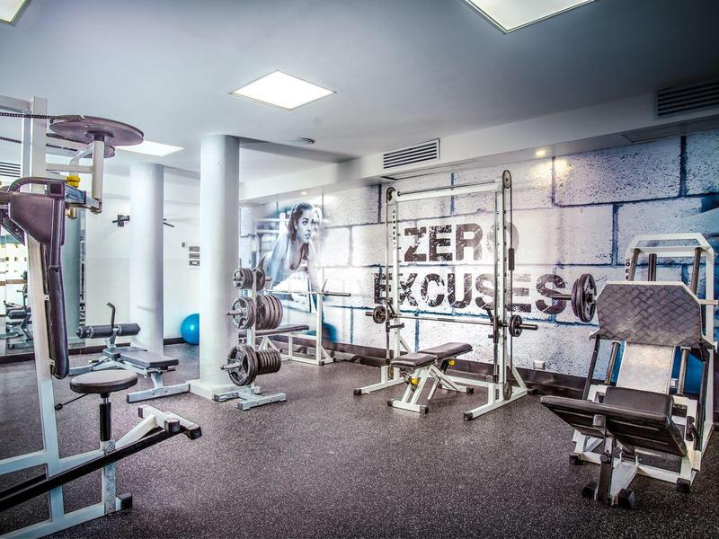 Modern gym with strength machines and wall featuring an inspiring quote