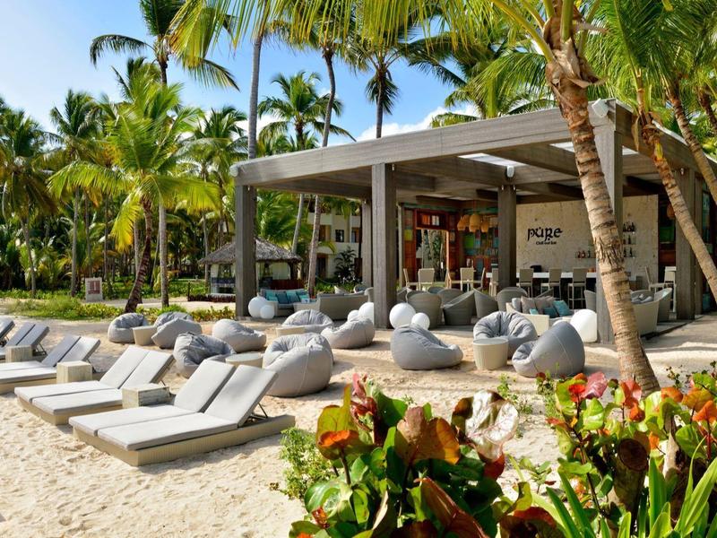 Modern outdoor area with lounge chairs and palm trees in tropical hotel resort