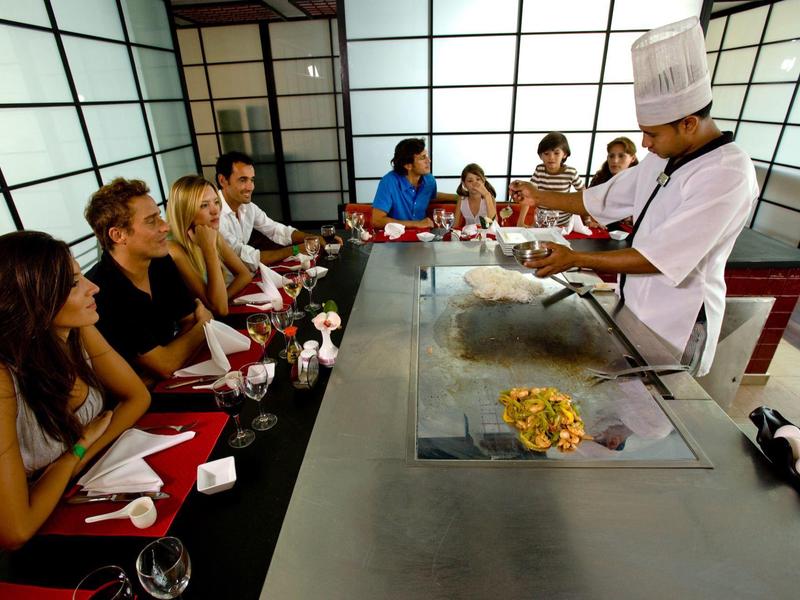 Group dining at Japanese teppanyaki table with chef in traditional attire