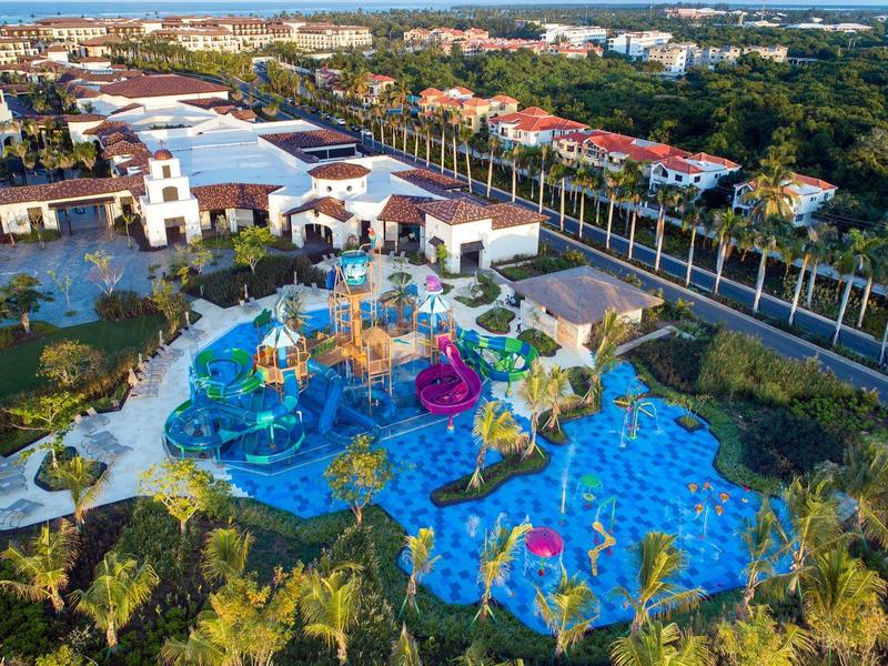 Grand parc aquatique avec toboggans colorés et aires de jeux dans un complexe hôtelier.