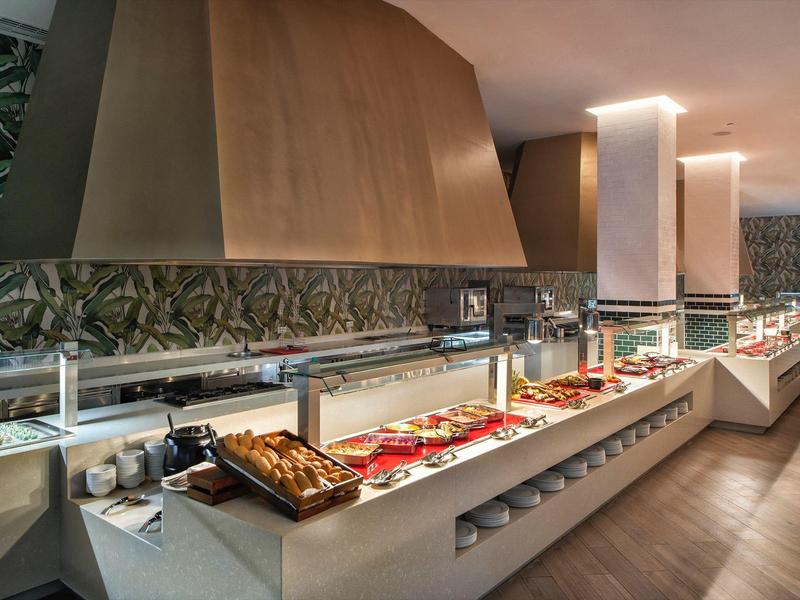 Buffet avec divers plats dans un restaurant moderne avec papier peint décoratif.