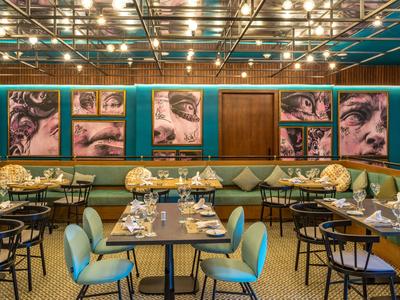 Modernes Restaurantinterieur mit farbenfrohen Wandgemälden und eleganten Sitzgelegenheiten.