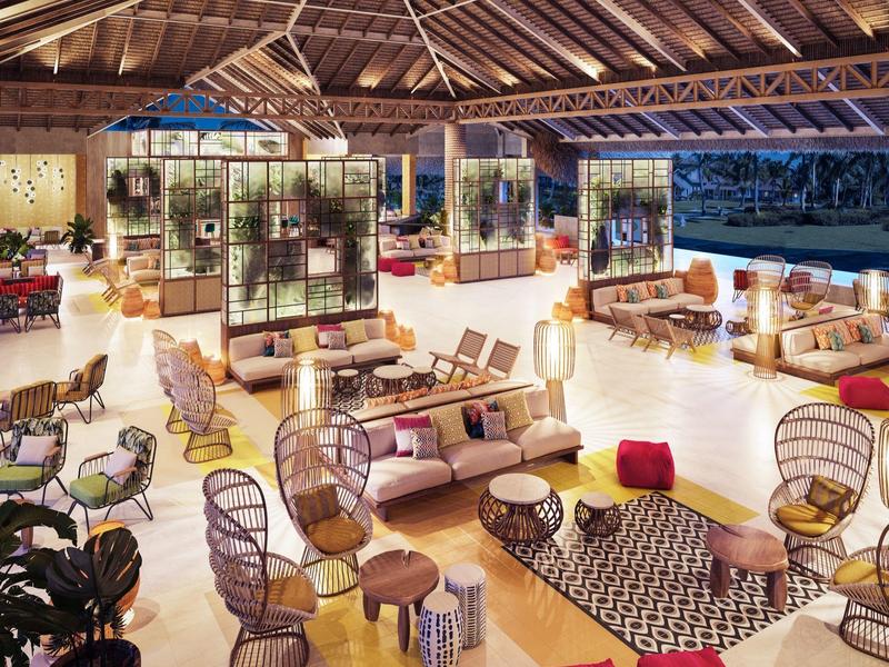 Una zona lounge aperta e arredata con stile con comode poltrone e divani sotto un tetto di legno.