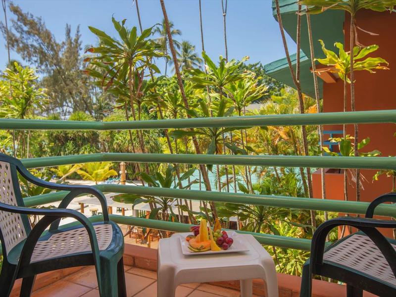 Terras met twee stoelen en een tafel met een bloemenarrangement voor tropische planten.