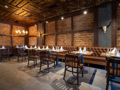 Gezellige eetruimte met houten tafels, stoelen en bakstenen muren.