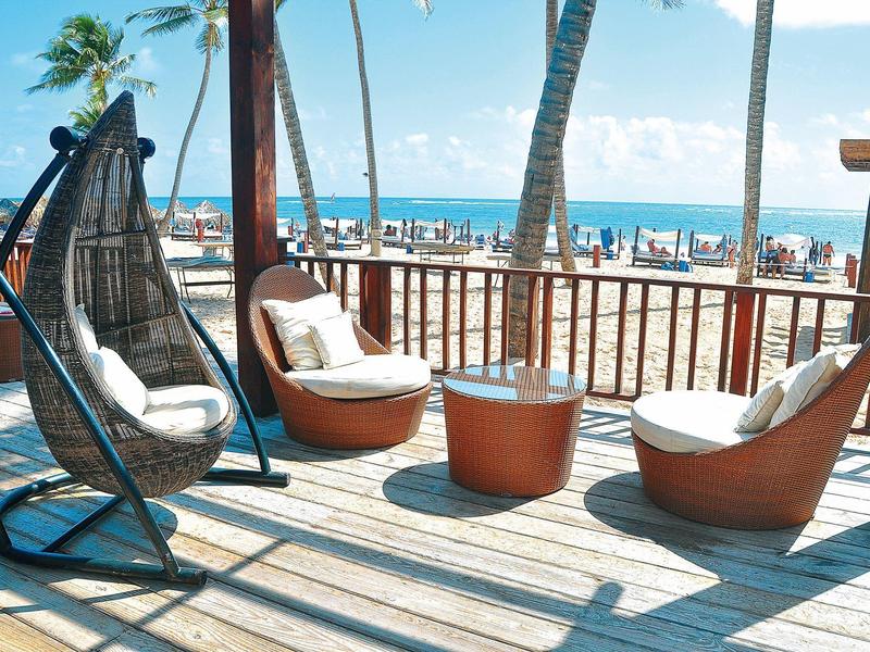 Terras met moderne stoelen met uitzicht op het strand en de zee op een zonnige dag.