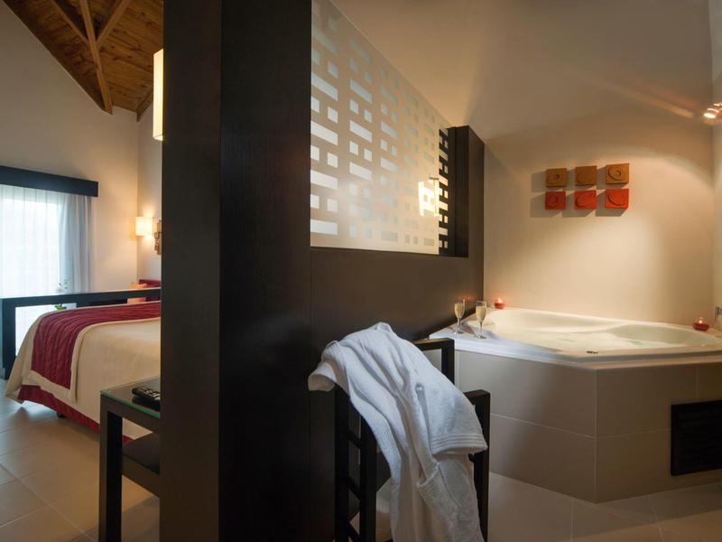 Moderne slaapkamer en badkamer met whirlpool en houten accenten in warme tinten.