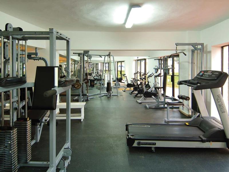 Modern gym with various strength and cardio equipment, bright and spacious.