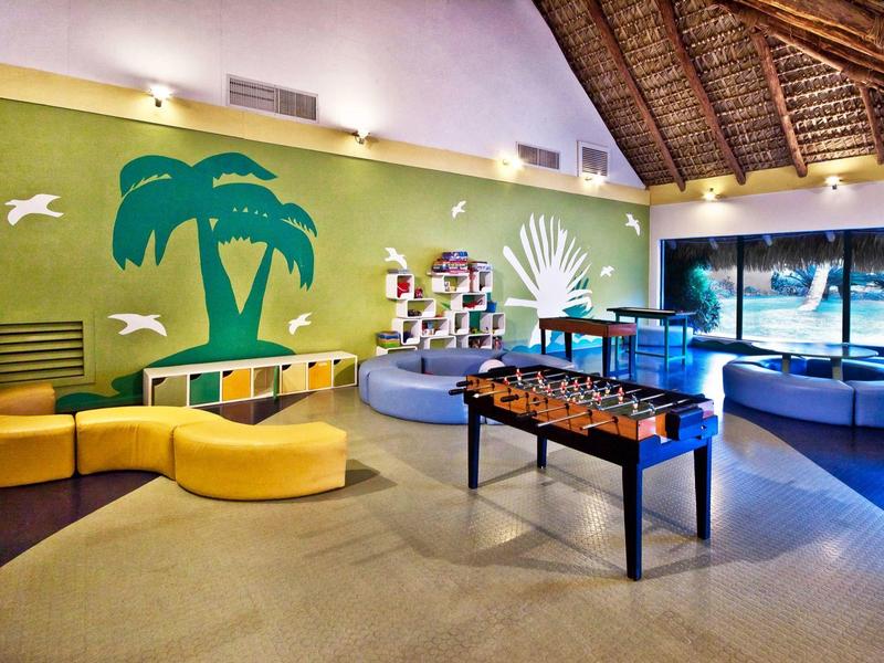 Espace de loisirs intérieur avec jeux et décoration murale colorée.