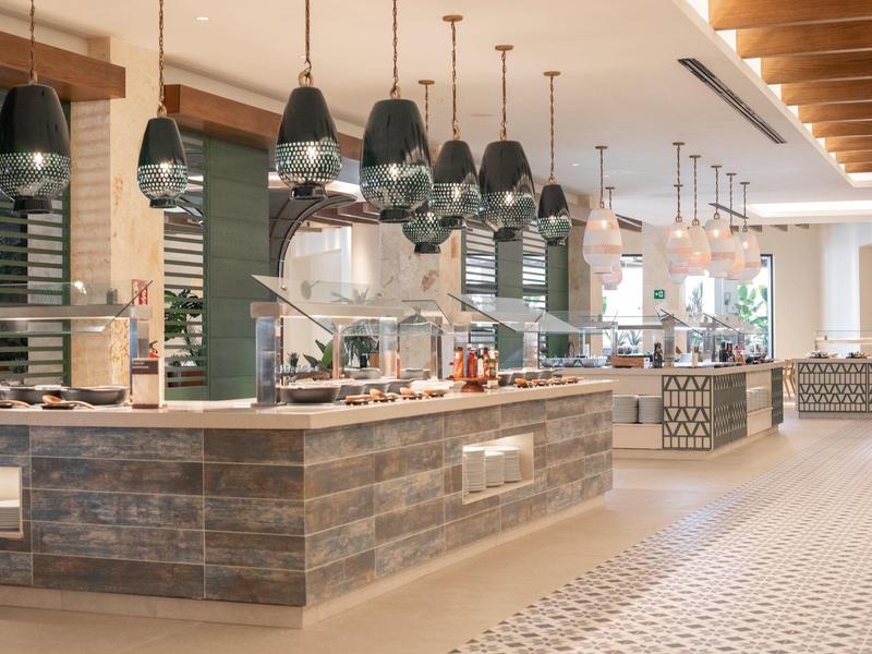 Espace petit-déjeuner moderne avec buffet et suspensions élégantes dans un hôtel.