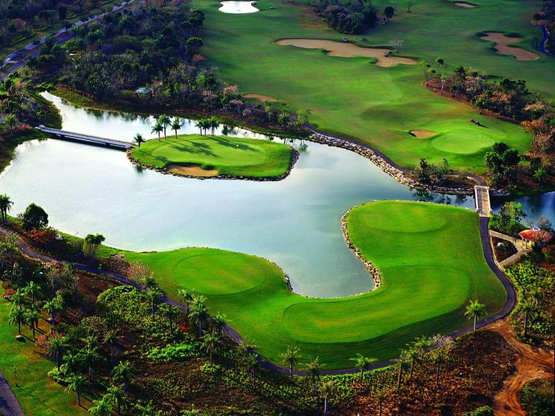 Golf course with water hazards and green fairways in a natural landscape