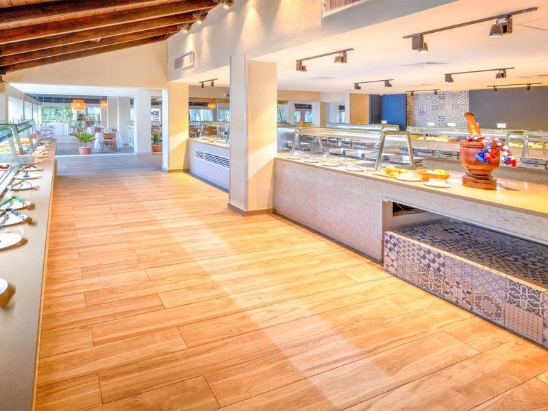 Bright, modern buffet area with wooden flooring and refrigerated display cases in a restaurant.