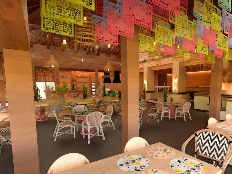 Amplia área de restaurante con asientos coloridos y decoraciones de papel colgadas del techo.