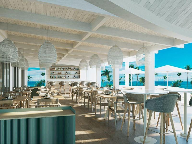 Lichte open terras met eetgedeelte en zeezicht op een zonnige dag.