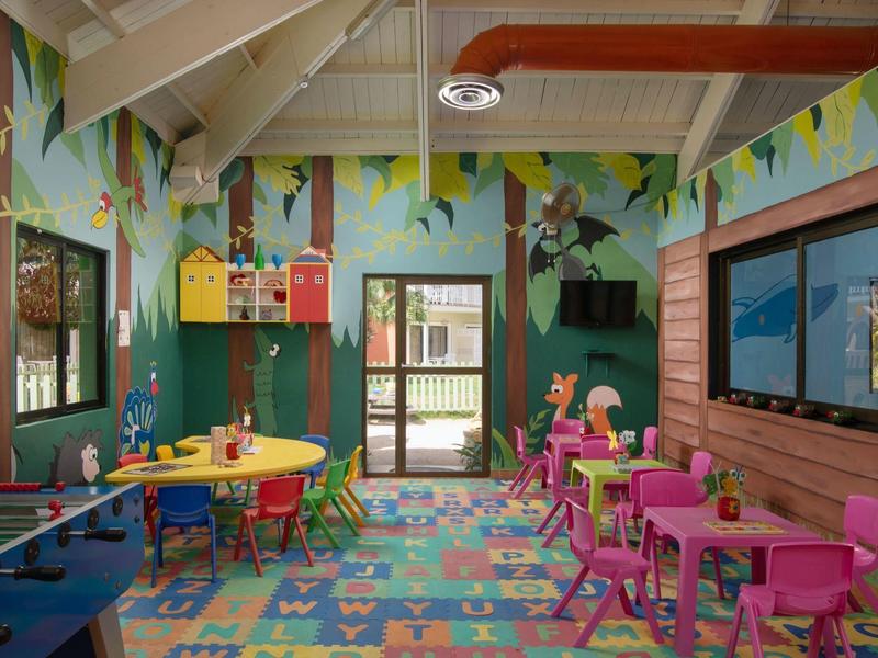 Kolorowy pokój zabaw dla dzieci z stołami, krzesłami i zabawkami pod pochylonym sufitem