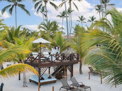 Strandbar mit Holzterrasse, Stühlen und Palmen im tropischen Resort