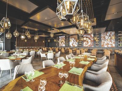 Ein stilvolles Restaurant mit modernen Lampen und gedeckten Tischen in einem Hotel.