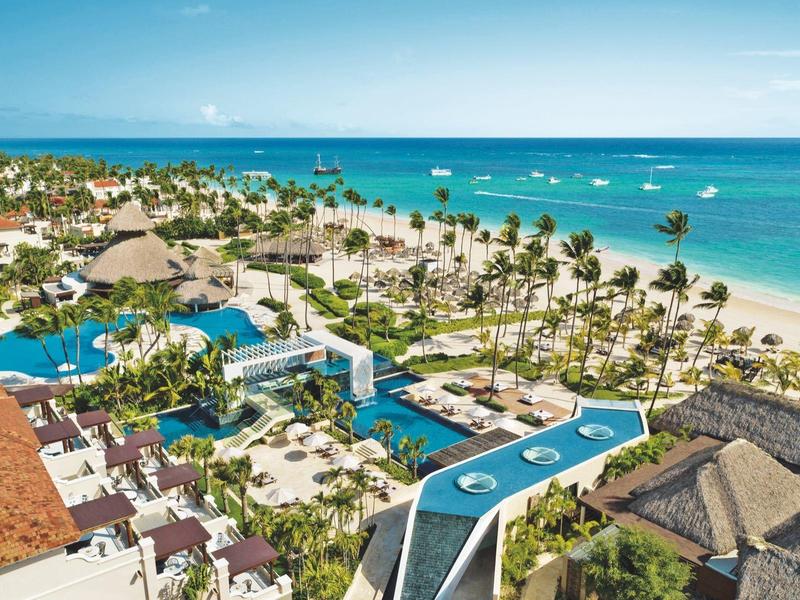 Luxe strandresort met zwembaden, palmbomen en uitzicht op turquoise zee