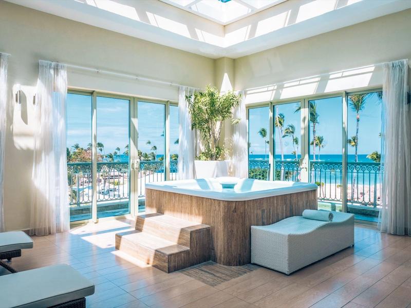 Luxurious indoor space with hot tub, panoramic windows, and ocean view.