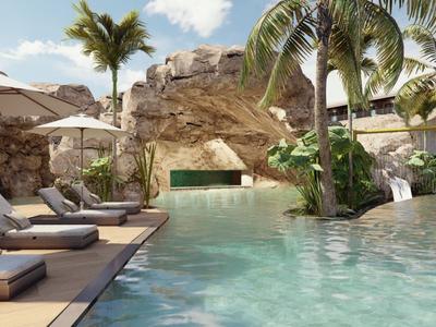Luxuriöser Hotelpool mit Sonnenliegen, Palmen und natürlicher Felskulisse unter blauem Himmel.