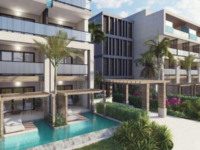 Moderner Hotelkomplex mit mehreren Etagen, Poolbereich und Palmen in tropischer Umgebung.