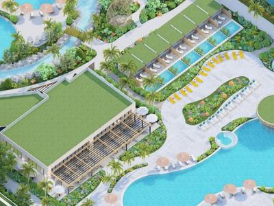 Luftaufnahme eines Hotels mit Swimmingpools, Sonnenschirmen und Wasserwegen, umgeben von Grün.