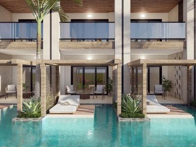 Moderner Hotelpool mit Liegen und Zimmern im Hintergrund, umgeben von Holz und Pflanzen.