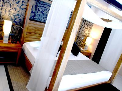 Modern hotelkamer met hemelbed en warme verlichting.
