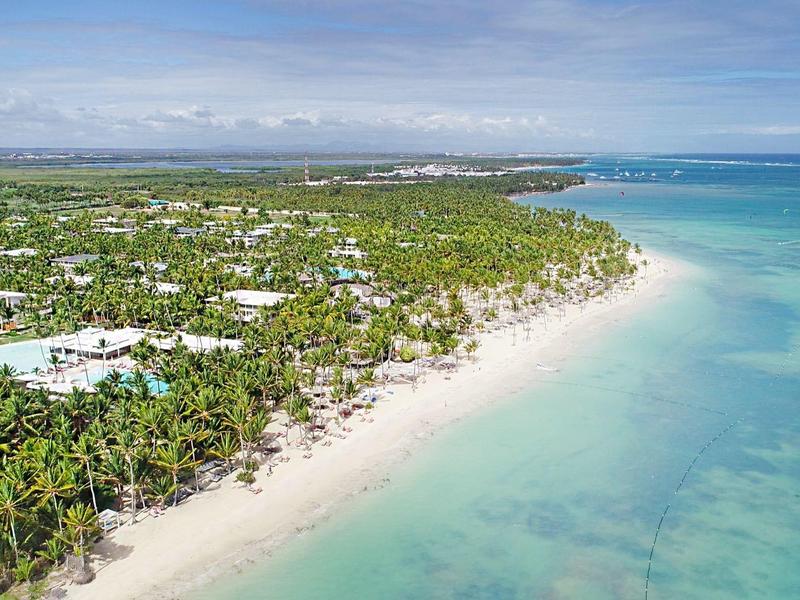 Luchtfoto van een tropisch strand met wit zand, palmbomen en helder blauw water