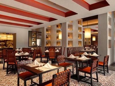 Elegantes Hotelrestaurant mit gedeckten Tischen und warmem Beleuchtungskonzept.