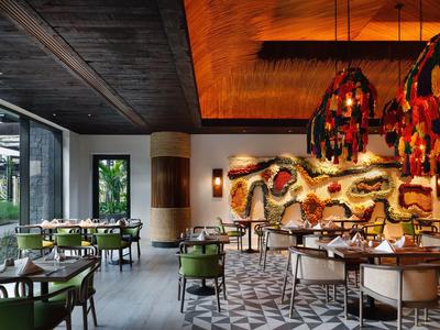 Modernes Restaurant mit Holzdecke, geometrischem Bodenmuster und dekorativer Wandinstallation.