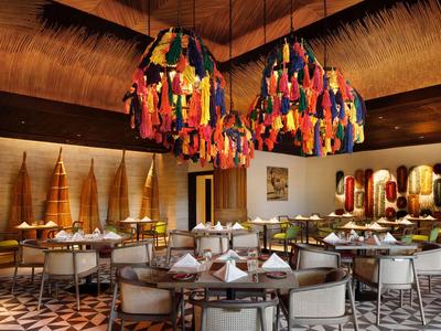 Elegantes Restaurant mit modernen Lampen aus bunten Quasten und stilvollen Sitzgelegenheiten.